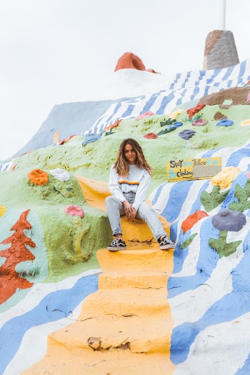 Woman Wearing Gray Pants Sitting on Multicolored Painted Steps
