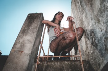 Woman Wearing Gray Tank Top Sitting on Red Ladder
