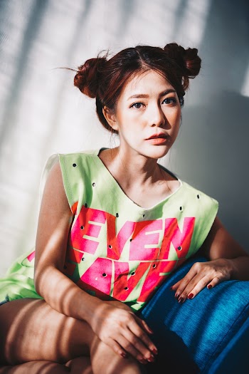Woman Wearing Green and Pink Sleeveless Mini Dress Sitting on Blue Sofa