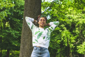 Woman Wearing Green and White Floral Long-sleeved Laying on Tree Bark