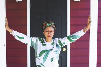 Woman Wearing Green and White Sweater Near Black Wooden Door