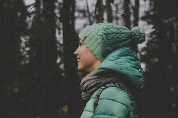 woman wearing green bobble hat while smiling
