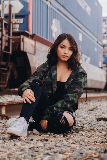 Woman Wearing Green Camouflage Jacket Sitting Near Train Railway