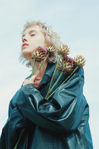 Woman Wearing Green Leather Jacket Holding Flowers
