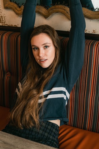 Woman Wearing Green Long-sleeved Shirt Sitting On Couch