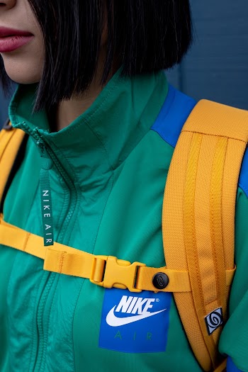 Woman Wearing Green Nike Zip Top and Yellow Backpack