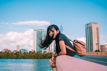 Woman Wearing Green Shirt And Brown Leather Backpack