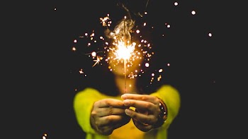 woman wearing green shirt holding sparkler