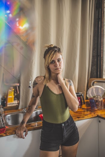 Woman Wearing Green Spaghetti Strap Blouse And Black Denim Short
