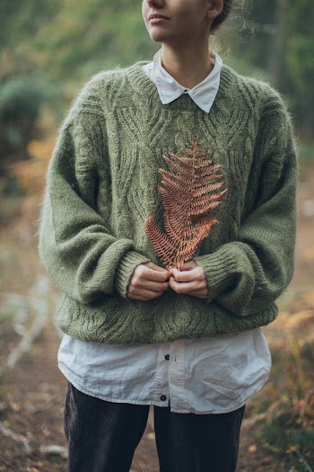 Woman Wearing Green Sweater Holding Dried Pine Leaf