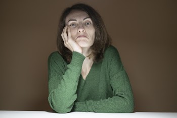 Woman Wearing Green V-neck Long-sleeved Shirt Sitting by the Table