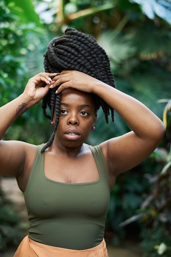 Woman Wearing GreenTank Top While Holding Her Hair