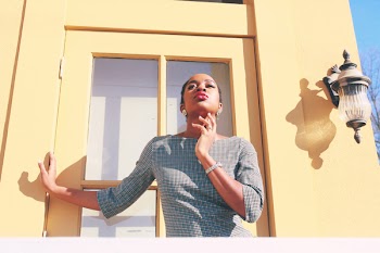 Woman Wearing Grey Long-sleeved Shirt Standing Beside Yellow Wooden Door