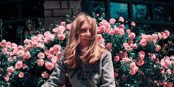Woman Wearing Grey Sweater Standing Near Pink Flowers