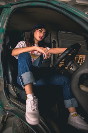 Woman Wearing Hat and Pants Sitting Inside the Vehicle