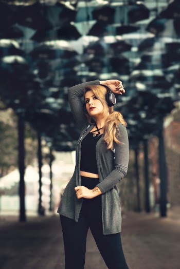 Woman Wearing Headphones Standing Under Tunnel