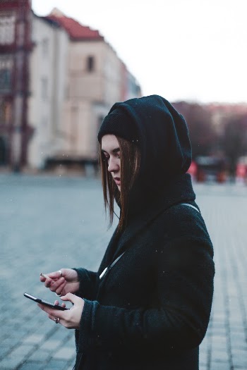 Woman Wearing Hoodie While Using Smartphone