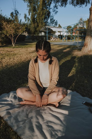 Woman Wearing in Brown Cardigan Sitting on White Mat