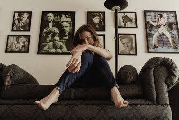 Woman Wearing Jeans Sitting On Sofa 