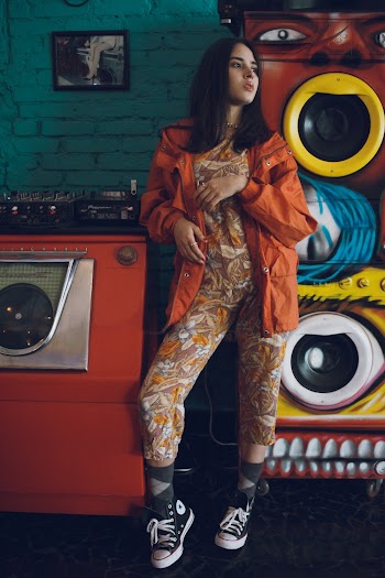 Woman Wearing Jumpsuit Standing Beside Speaker