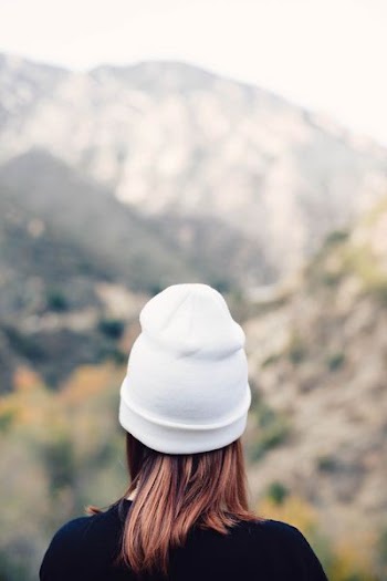 woman wearing knit hat facing through mountains
