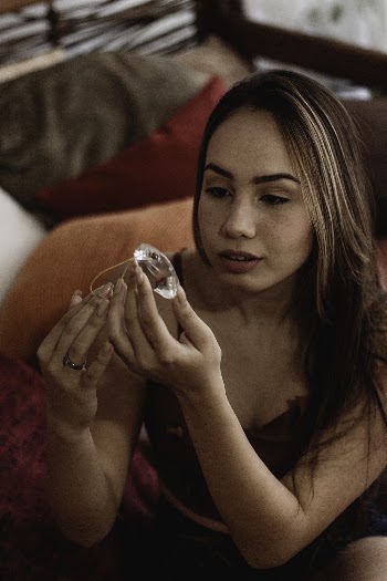 Woman Wearing Maroon Crop Top Holding Clear Diamond Gemstone
