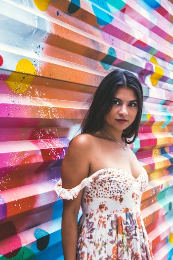 Woman Wearing Multicolored Floral Dress Behind Wall