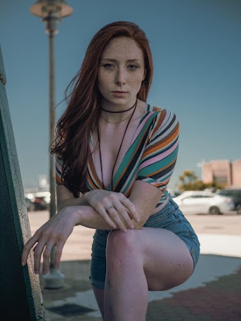 Woman Wearing Multicolored Striped Deep V-neck Top and Blue Denim Shorts