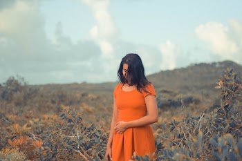 Woman Wearing Orange Cap-sleeve Dress Standing Surrounded by Plants