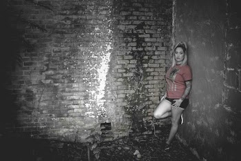 Woman Wearing Orange Crew-neck Short-sleeved Shirt Leaning on Concrete Wall