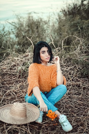 Woman Wearing Orange Knit Sweater and Blue Denim Jeans