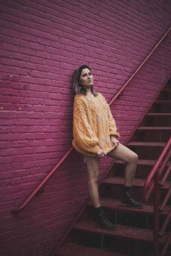 Woman Wearing Orange Knit Sweater Standing on Stair