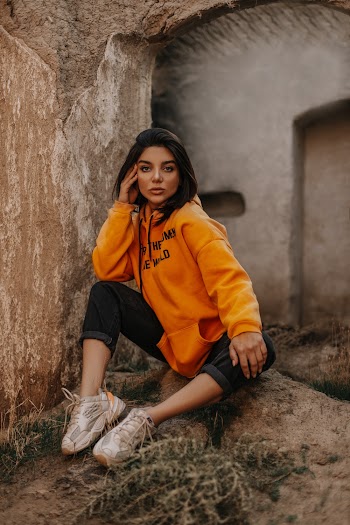 Woman Wearing Orange Pullover Hoodie and Black Capri Pants