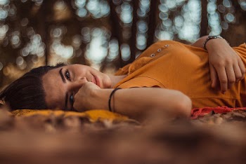 Woman Wearing Orange Top Laying Down