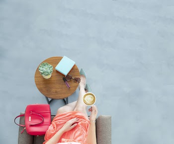 Woman Wearing Peach Skirt Sitting on Sofa Chair Holding a Cup of Coffee