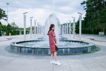 Woman Wearing Pink Crew-neck Long-sleeved Midi Dress Standing Concrete Outdoor Fountain