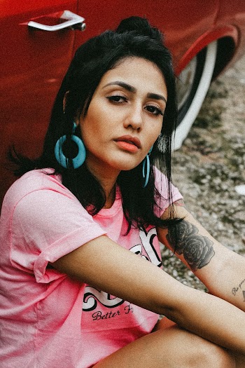 Woman Wearing Pink Crew Neck Shirt Sitting Beside Red Vehicle