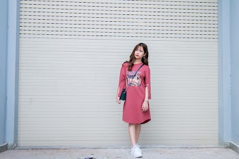 Woman Wearing Pink Long-sleeved Dress Standing Behind the Wall