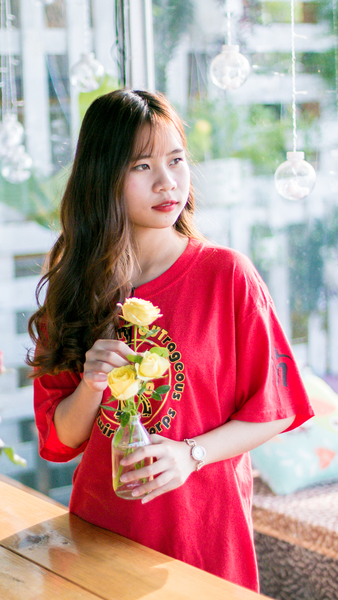 Woman Wearing Pink Scoop-neck Shirt While Holding Yellow Flowers