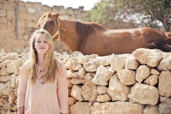 Woman Wearing Pink V-neck 3/4 Sleeved Shirt With Eyeglasses Standing in Front of Brown Horse