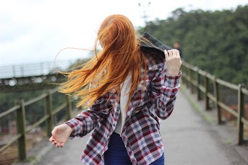 Woman Wearing Plaid Button-up Sport Shirt While Holding Black Hood