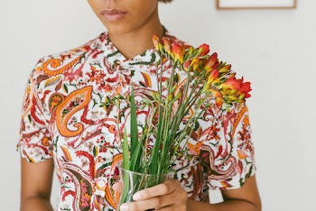 Woman Wearing Printed Shirt While Holding A Flower Vase