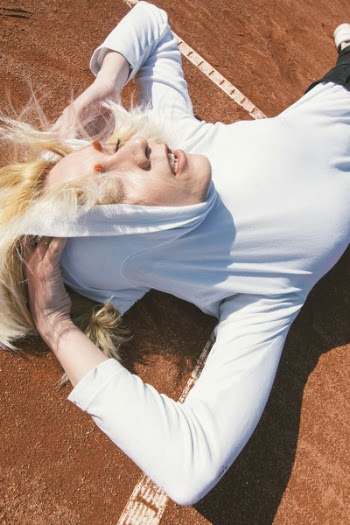 Woman Wearing Pull over Hoodie Laying on Brown Carpeted Floor
