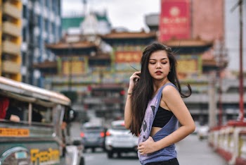 Woman Wearing Purple Sleeveless Shirt Across City Building