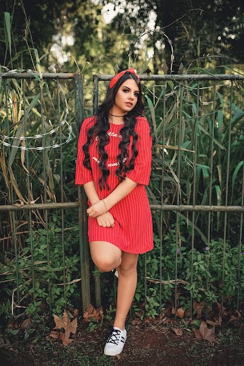 Woman Wearing Red 3/4-sleeved Dress Standing Beside Green and Gray Metal Gate