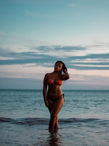 Woman Wearing Red and Black Bikini Set Standing While Touching Her Hair