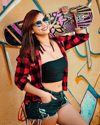 Woman Wearing Red and Black Plaid Dress Shirt Carrying Pink and Black Skateboard