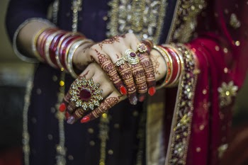 Woman Wearing Red And Gold Dress Holding Up Hands