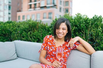 Woman Wearing Red and White Floral V-neck Dress Seating on Gray Couch
