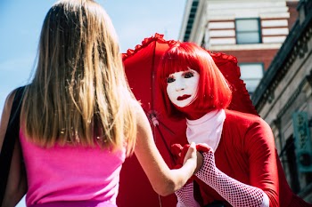 Woman Wearing Red and White Suit Holding Girl Wearing Pink Top